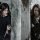 Daryl and Maggie lurk behind either side of a wall with bloody knives drawn.